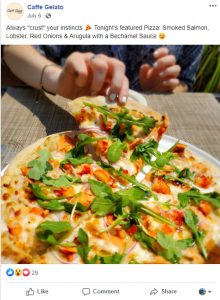 Facebook post of woman's right hand taking a slice of pizza from a full pie