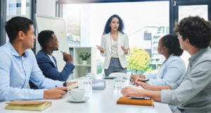 Woman standing in front of a group of business associates giving a presentation